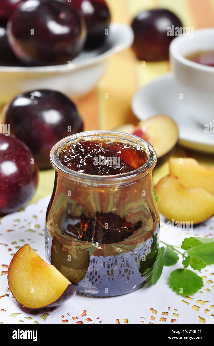 Confettura di prugne in un vasetto di vetro e frutta fresca Foto Stock