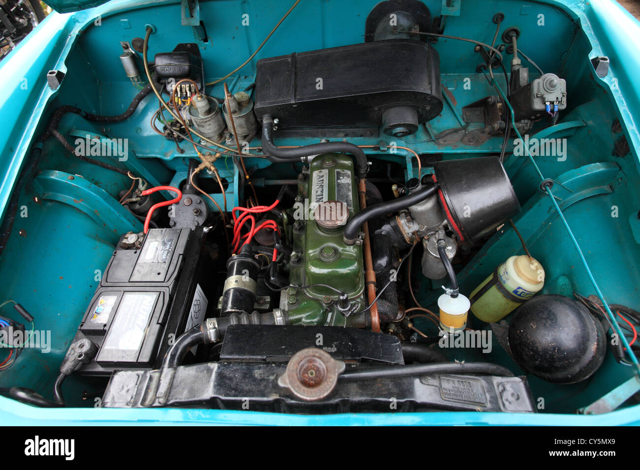 Aprire il cofano del motore di un auto che mostra il motore nel suo vano da una piccola vecchia famiglia britannica auto. Foto Stock