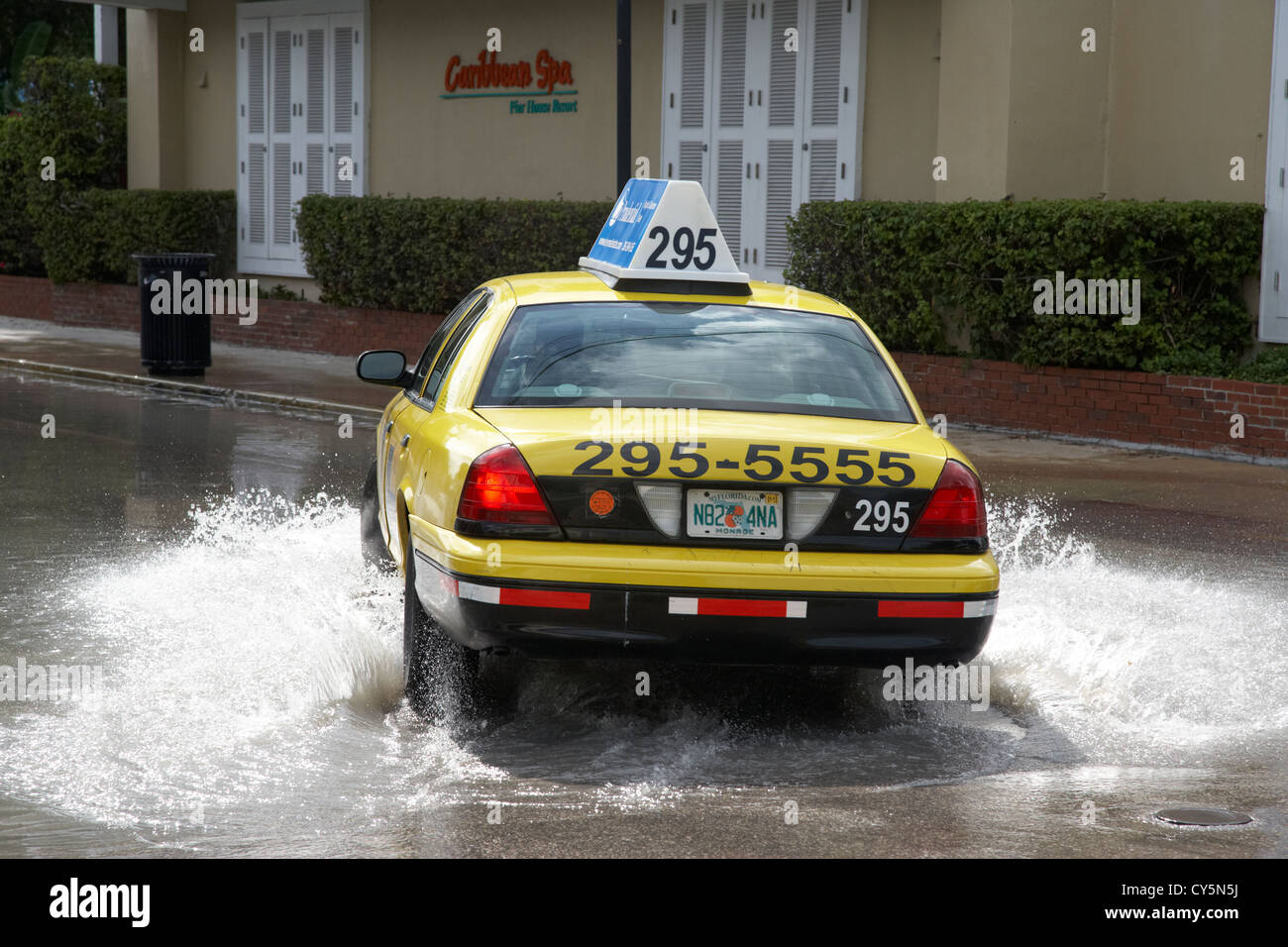 Giallo taxi guida attraverso strade allagate dalla pioggia pesante key west florida usa Foto Stock