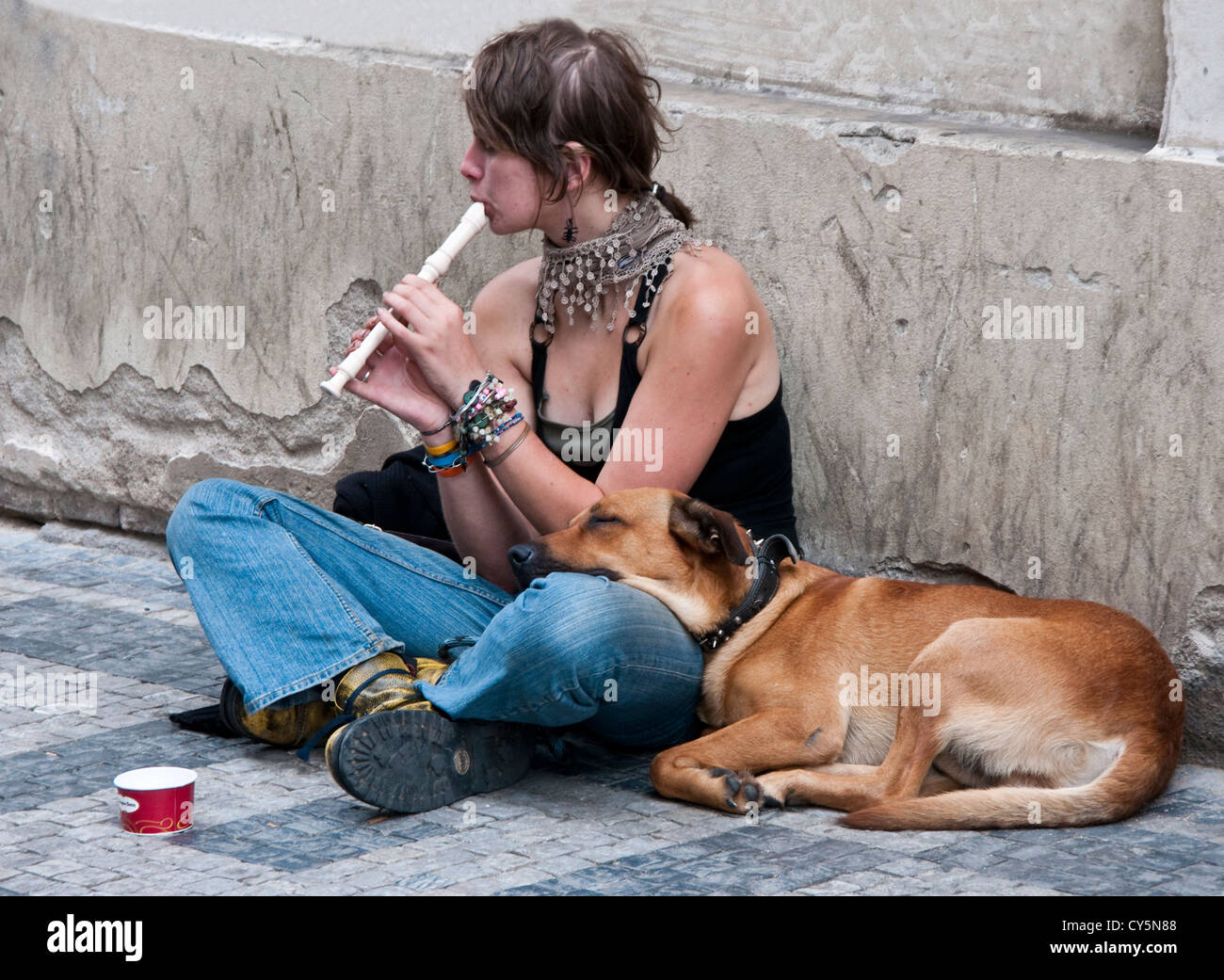 Giovane donna con il suo cane di elemosinare sulla strada di Praga Foto Stock