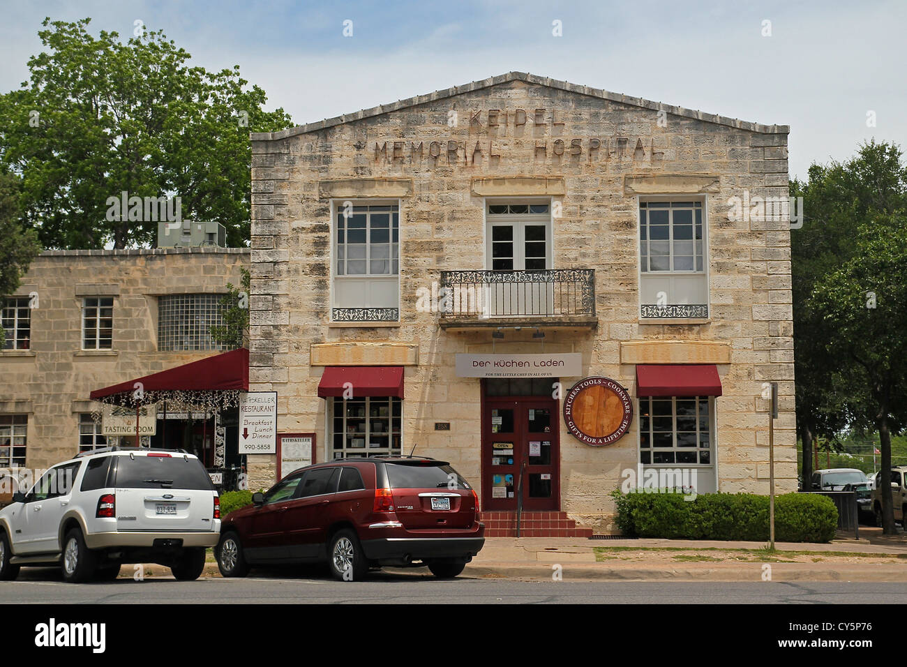 Edificio di pietra calcarea che una volta ha tenuto un ospedale e ora ospita negozi di culinaria in Fredericksburg, Texas Foto Stock