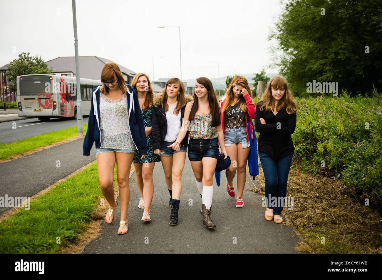 Un gruppo di sei 6 giovane adolescente inglese britannico welsh teen ragazze adolescenti amici camminando insieme all'aperto REGNO UNITO Foto Stock