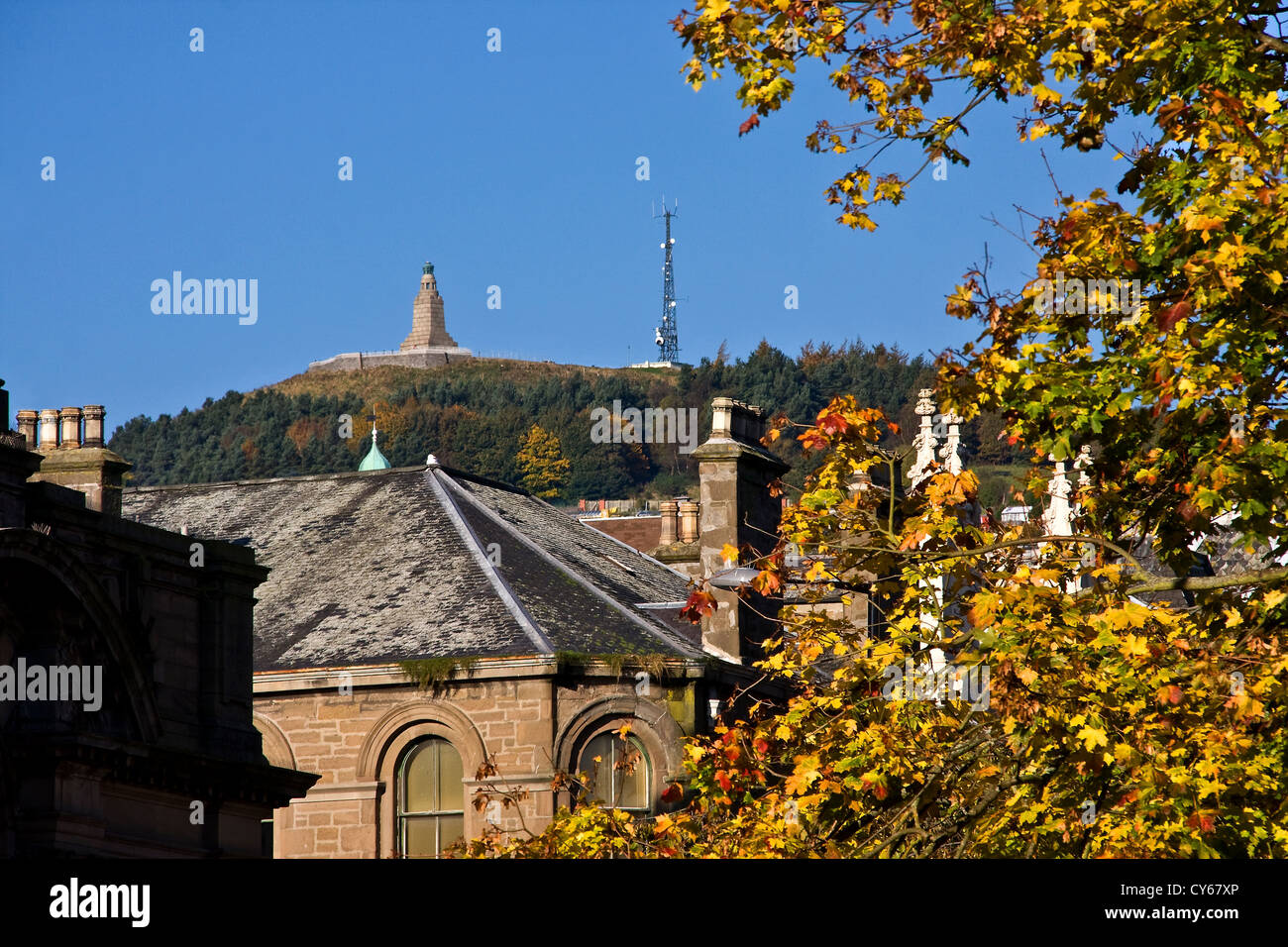 Un autunno vista orizzontale della legge Hill monumento tra tetti e alberi a Dundee, Regno Unito Foto Stock