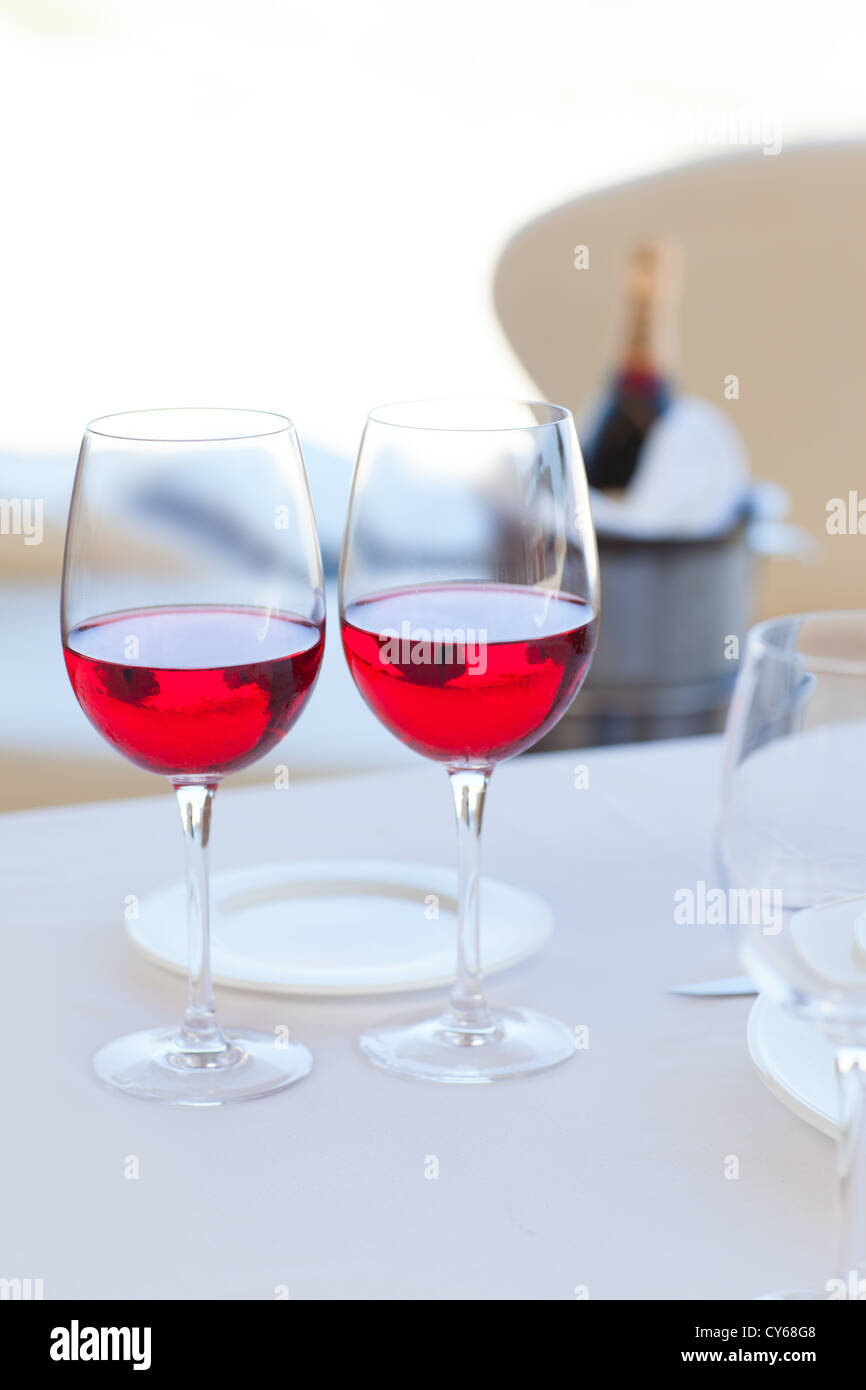 Due bicchieri di vino rosso e una bottiglia in background sul Secchiello per ghiaccio Foto Stock