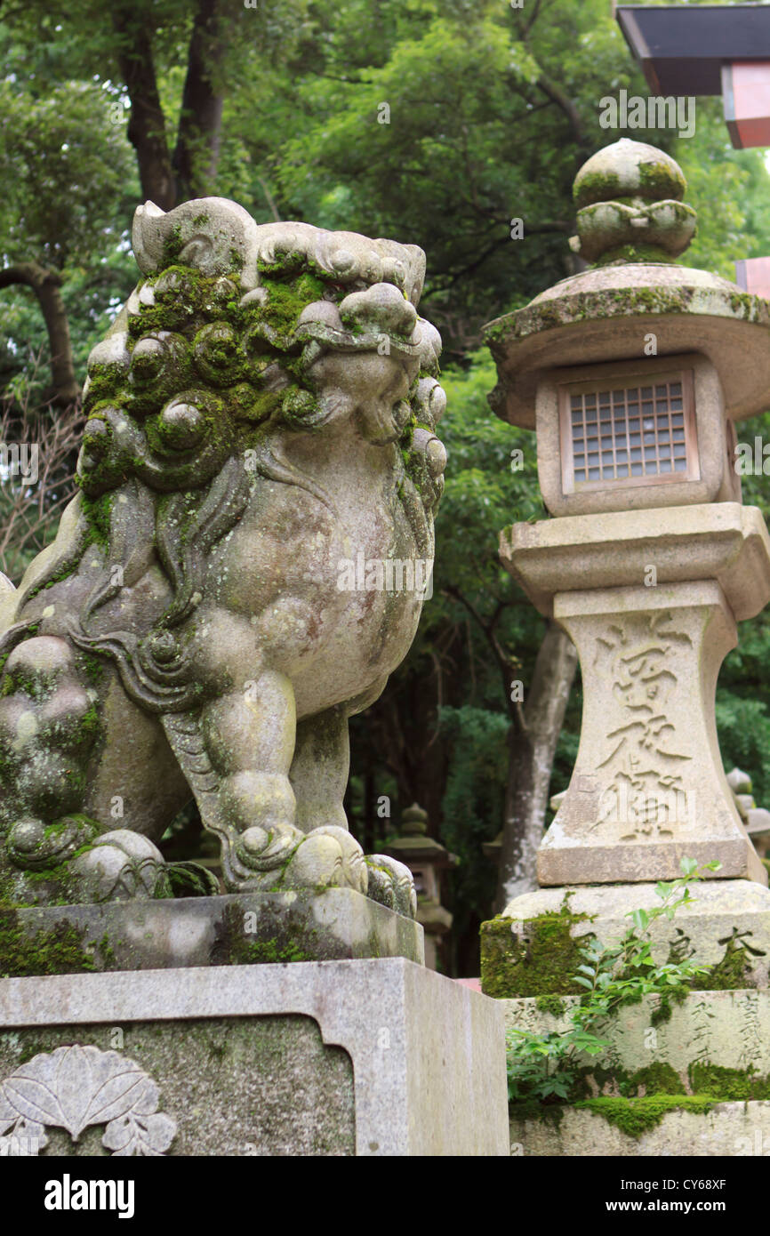 Custode di un leone di pietra tradizionale lanterna di pietra all'ingresso Kasuga-Taisha Santuario a Nara, Giappone. Foto Stock