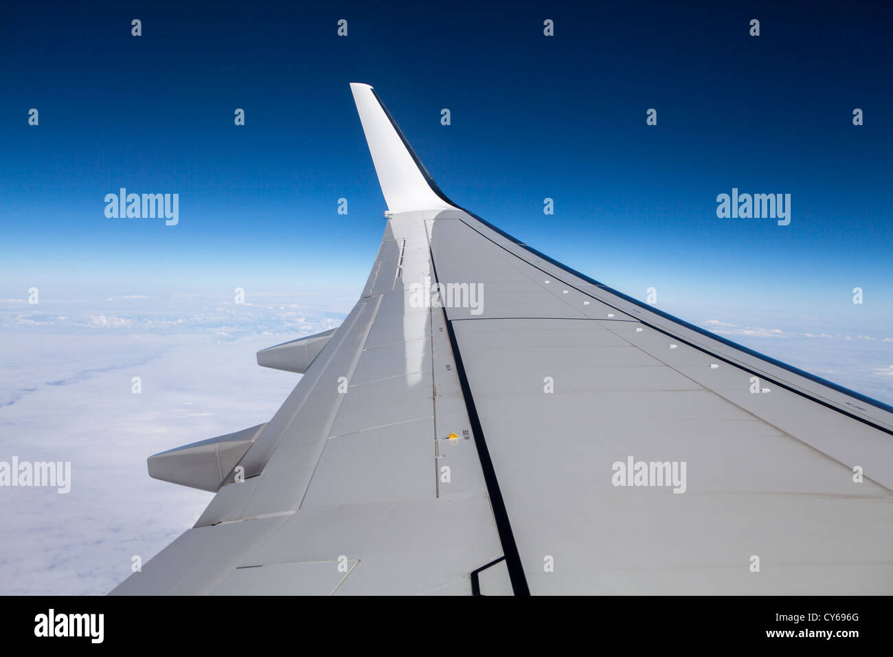 Aereo Boeing-737 ala come visto da un piano di vetro con un luminoso cielo blu. Foto Stock