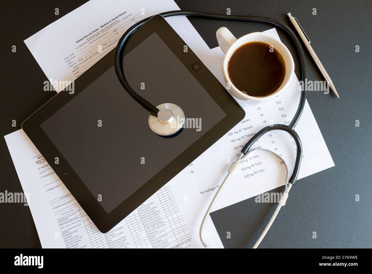 Tavoletta digitale con uno stetoscopio e documenti Foto Stock