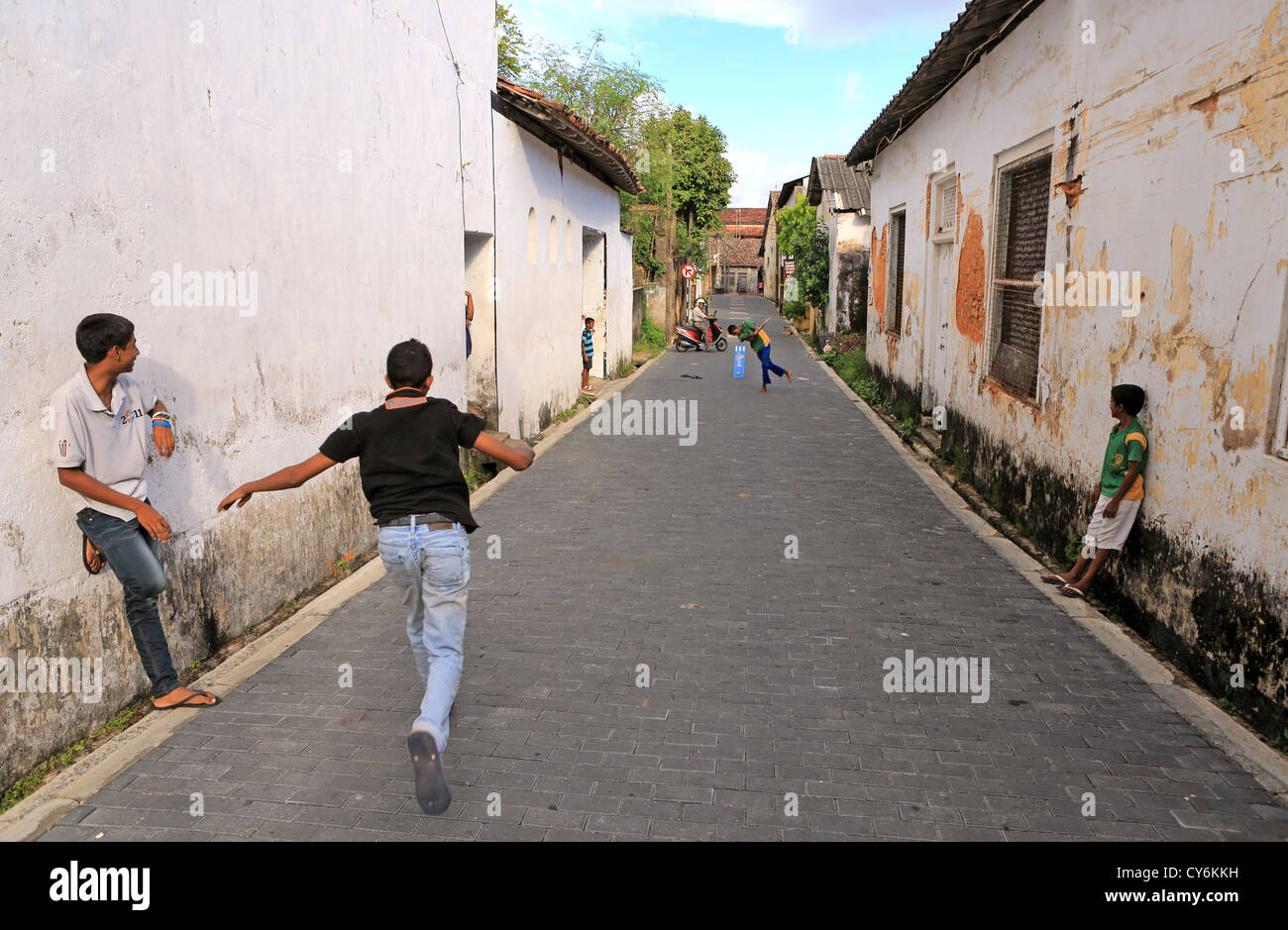 Il governo dello Sri Lanka ragazzi giocare a cricket in strada all'interno di Forte Galle. Foto Stock