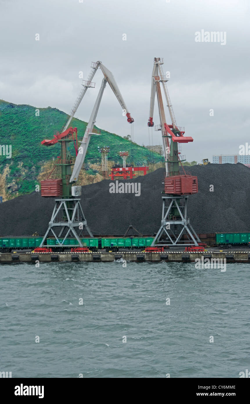Gru della nave nel porto di carboni di carico in un carrello ferroviario Foto Stock