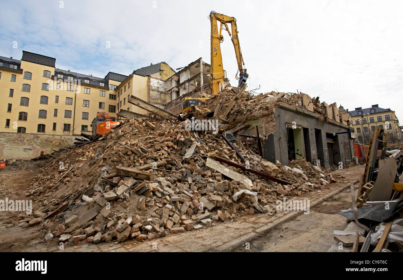 Demolizione case a Stoccolma e un escavatore sulle macerie dopo la demolizione Foto Stock