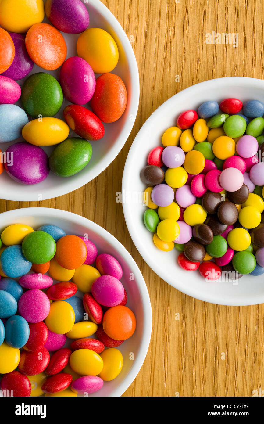Tre differenti dimensioni di caramelle colorate in ciotole di ceramica Foto Stock