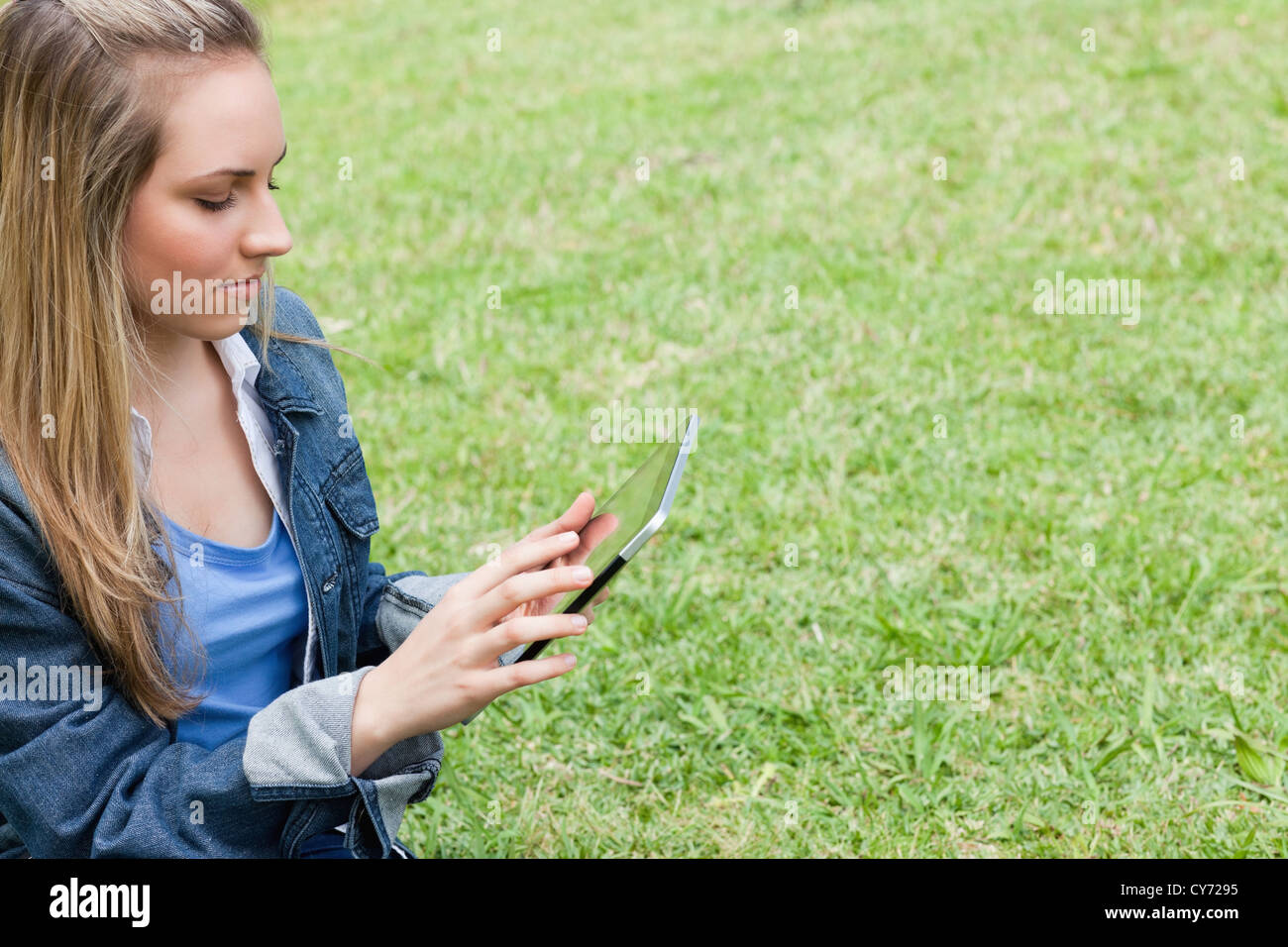 Giovane ragazza grave utilizzando il suo tablet pc in campagna Foto Stock