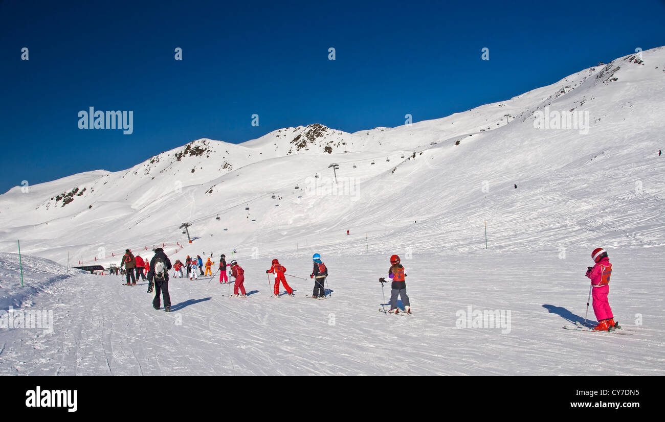 Gruppo di bambini su una lezione di sci su una pista facile- Les Menuires (Francia) Foto Stock