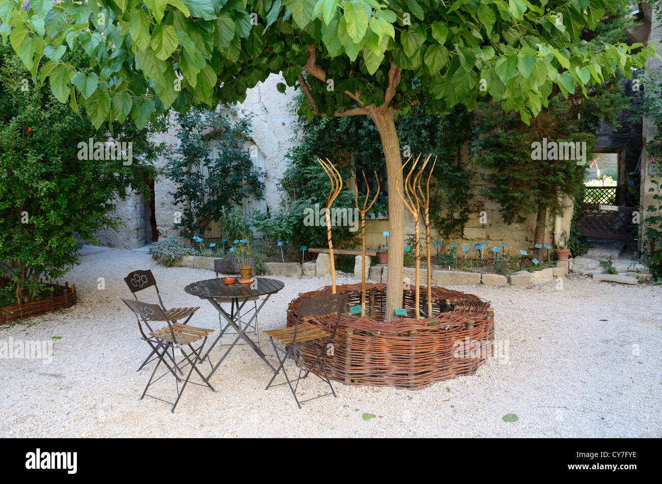 Giardino medievale con banco di lavoro di vimini, forcelle di legno, tavolo e sedie Uzès o Uzes Gard Francia Foto Stock