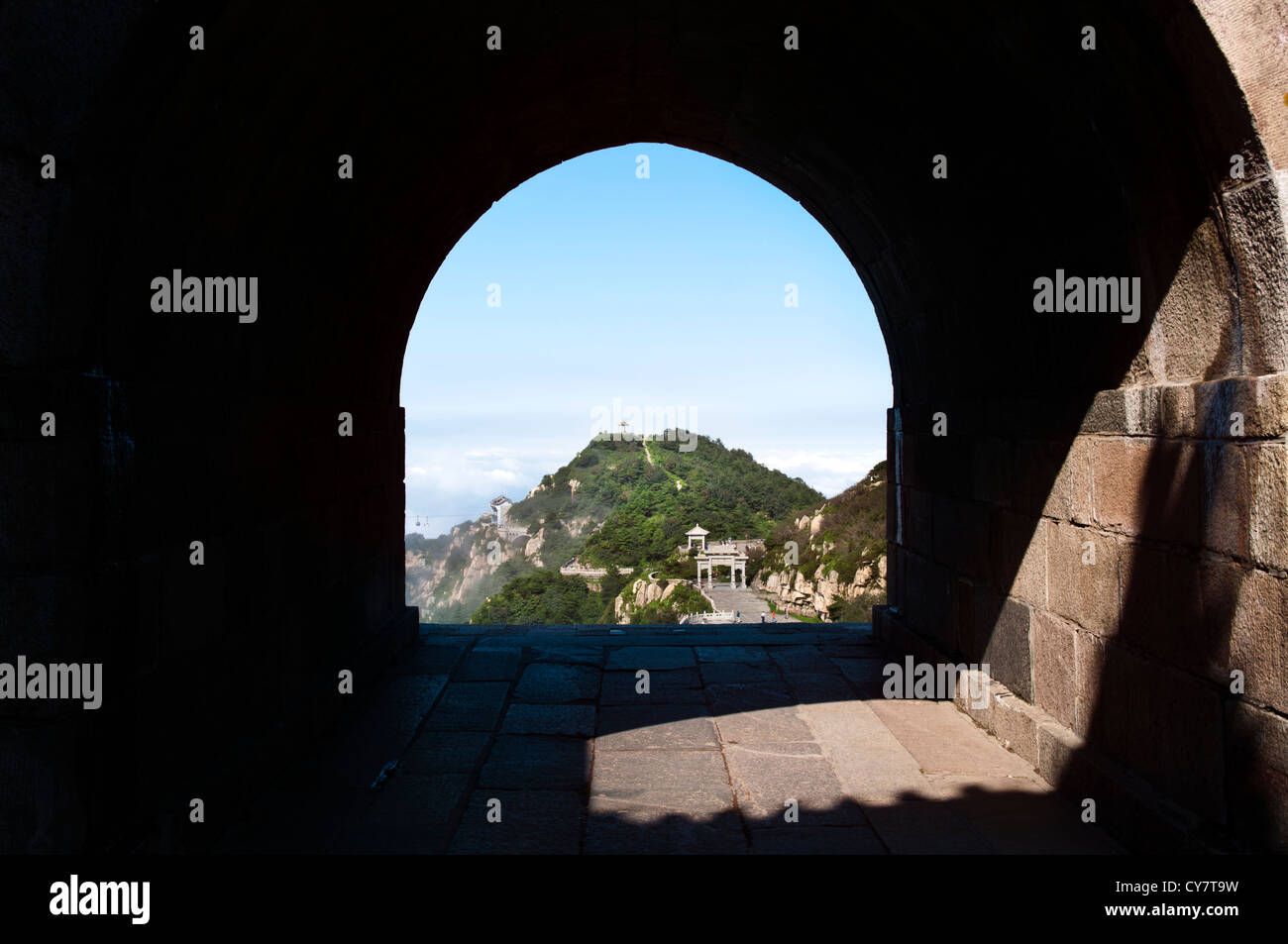 Un arco in pietra offre una vista di uno dei Tai Shan il vertice di picchi nella provincia di Shandong, Cina Foto Stock