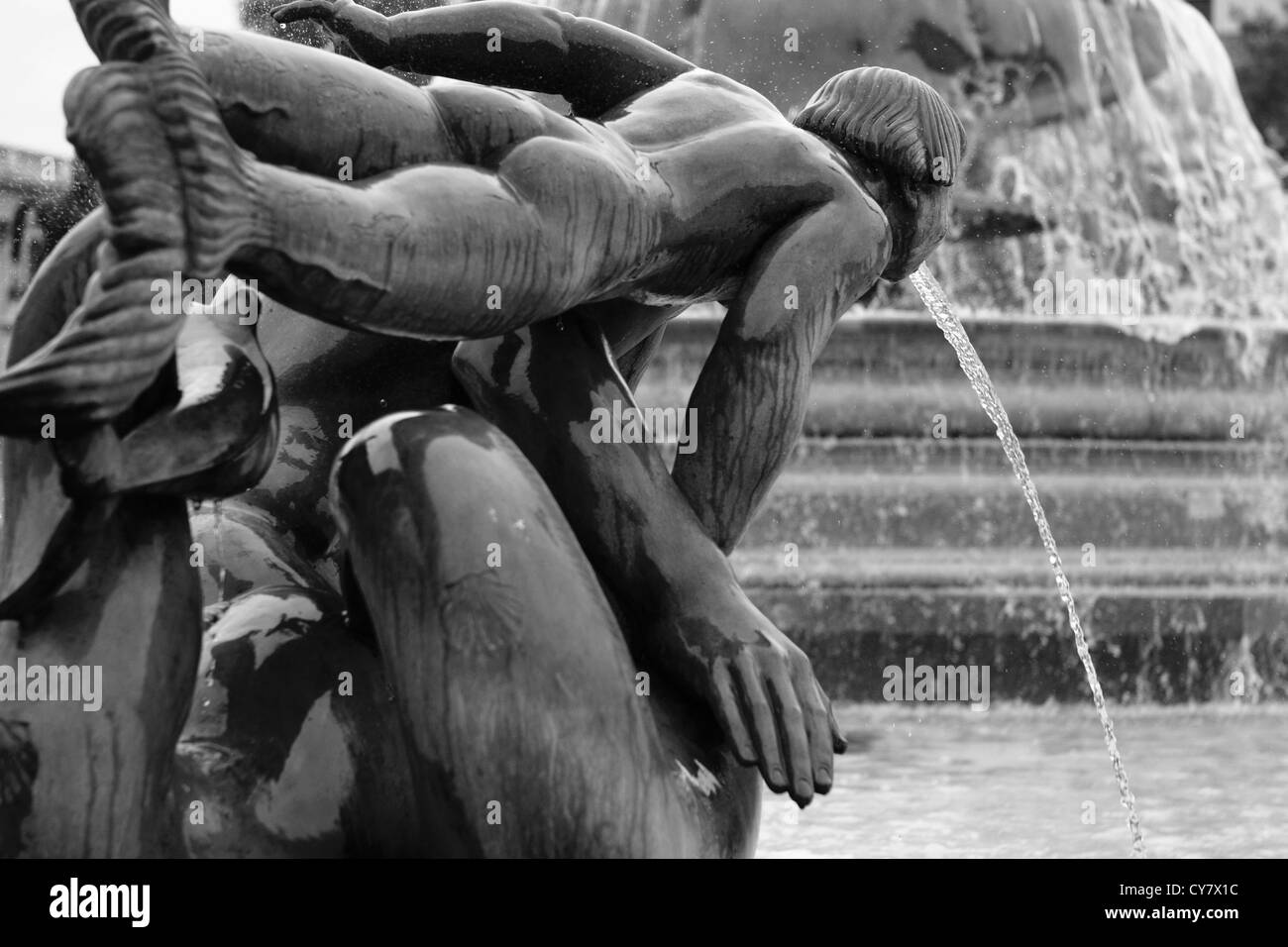 Una vista di una parte di una scultura d'acqua in Trafalgar Square, Londra, con parte di una fontana in background Foto Stock