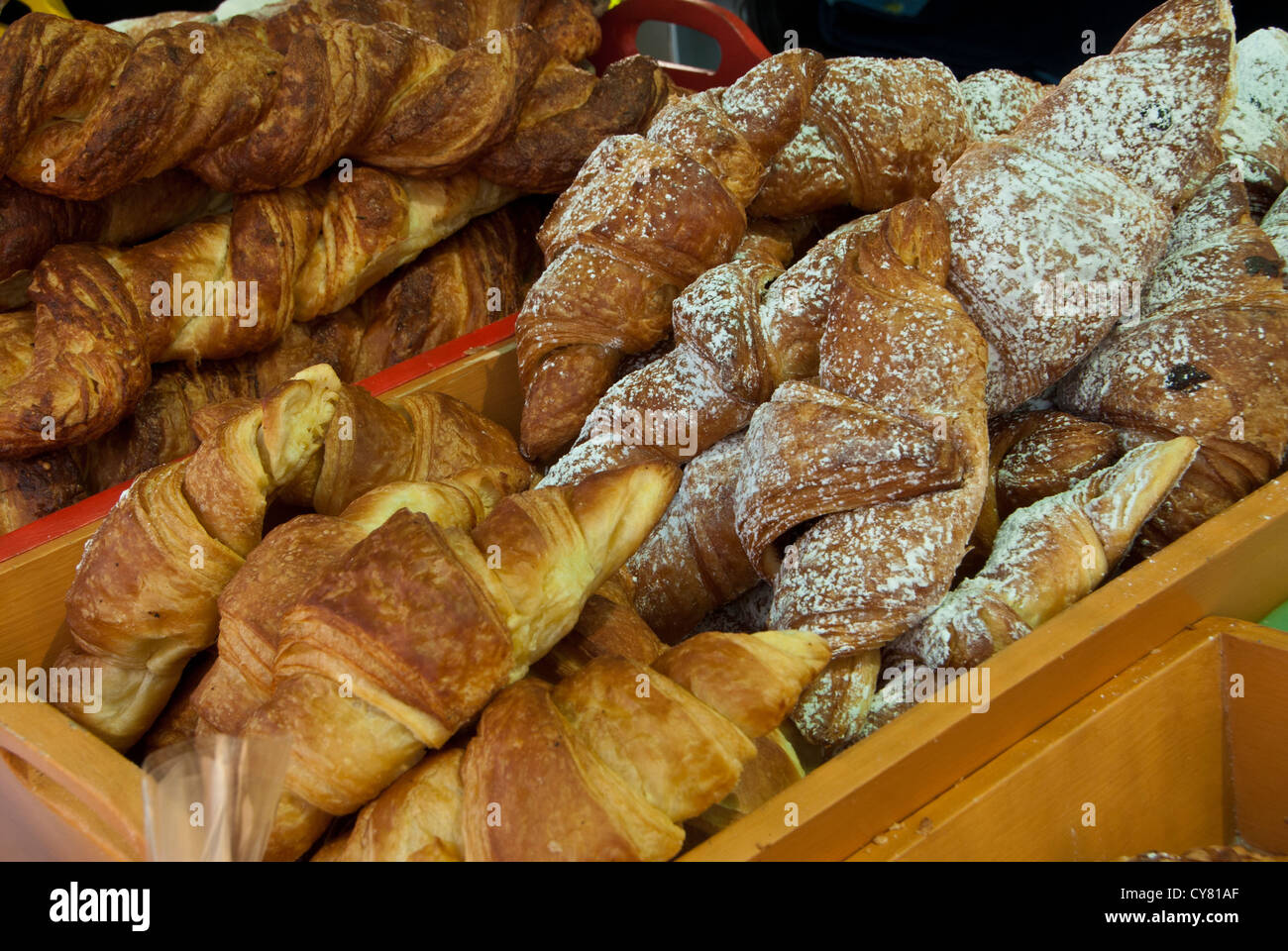 Croissant sul display in una scatola di legno in un fornaio stallo del mercato Foto Stock