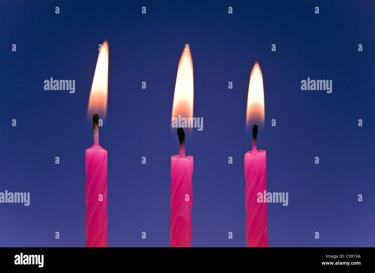Tre illuminati candeline di compleanno Foto Stock