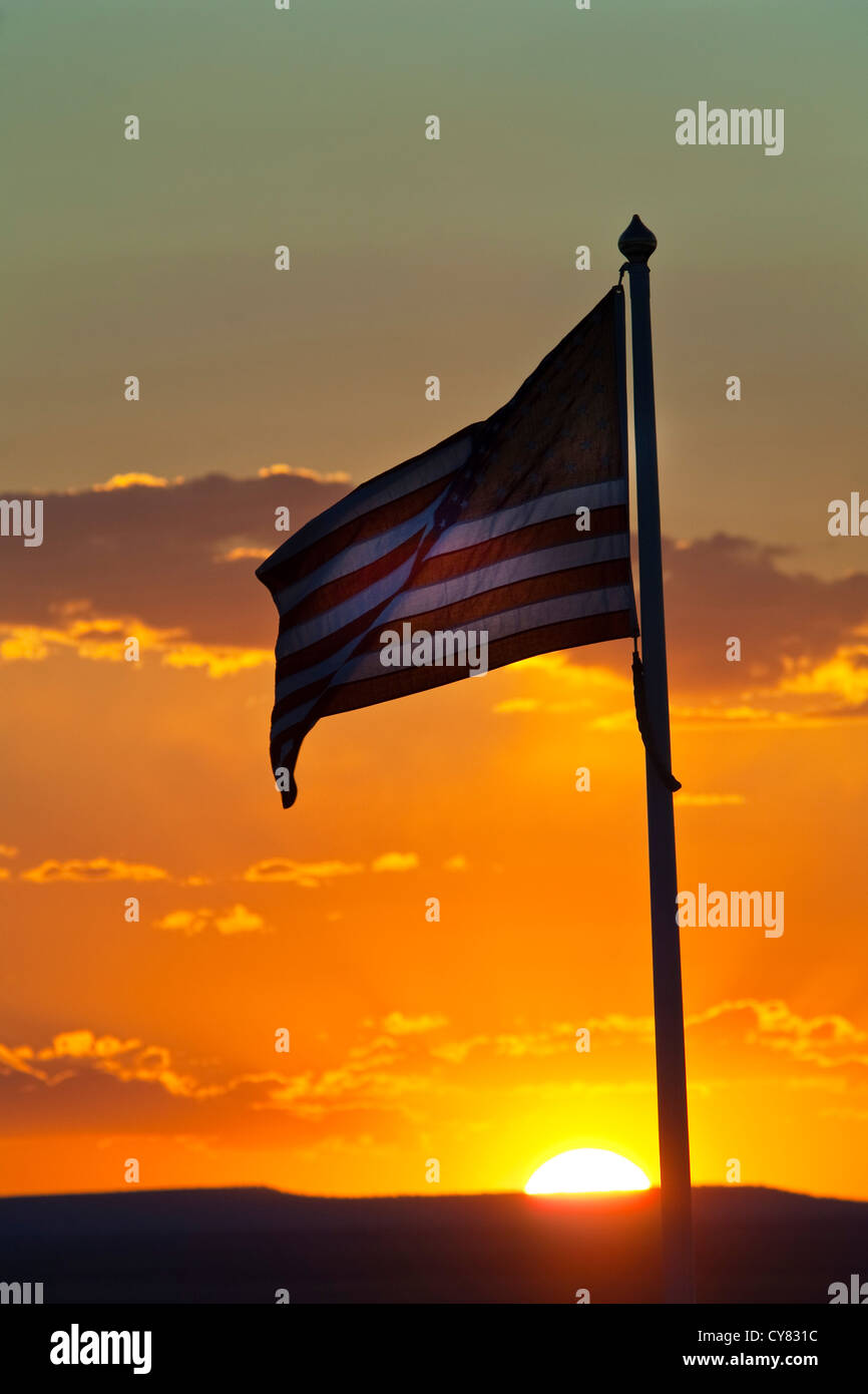 Tramonto dietro la bandiera americana sventolare nel vento vicino a Winslow, Arizona Foto Stock