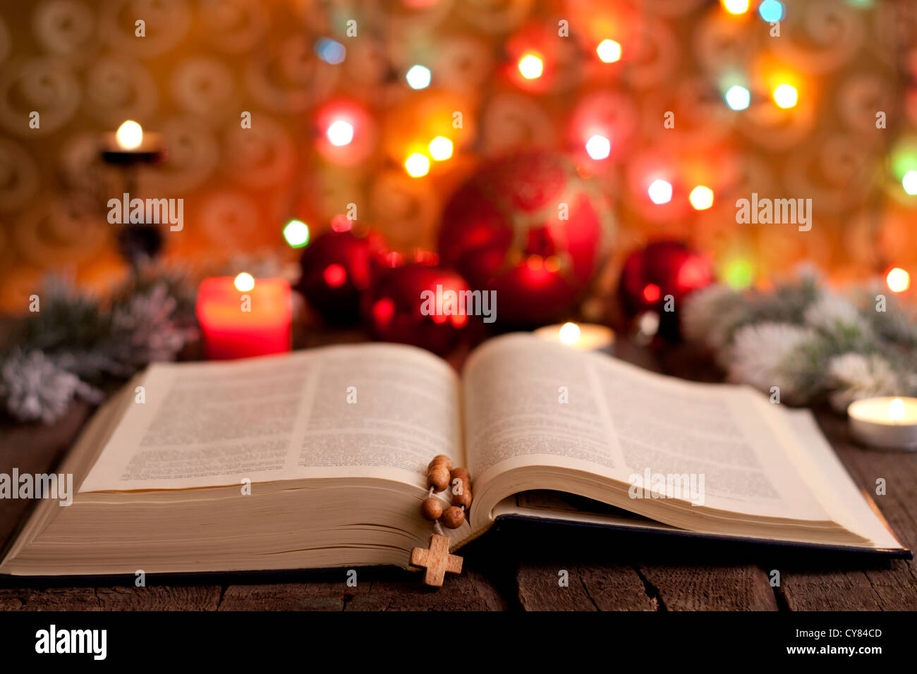Il Natale e la bibbia con candele sfocata sfondo luminoso Foto Stock