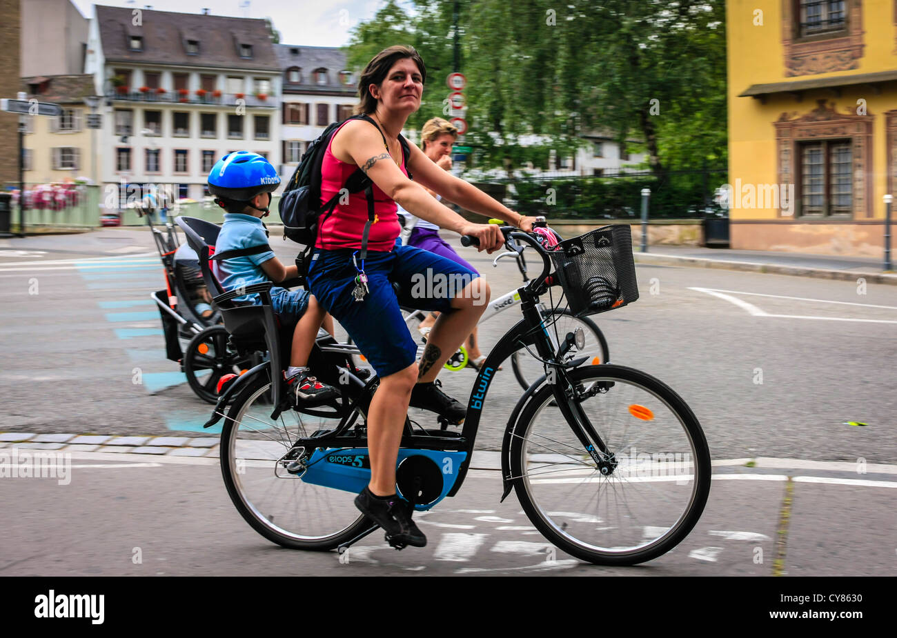 Donna francese su una bicicletta con un seggiolino per bambini sul retro  Foto stock - Alamy