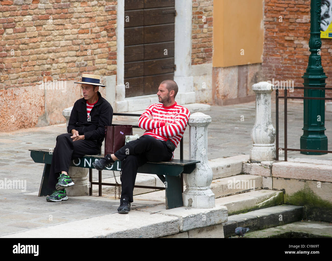 Venezia - Due gondolieri nella loro caratteristica divisa in attesa per il business Foto Stock
