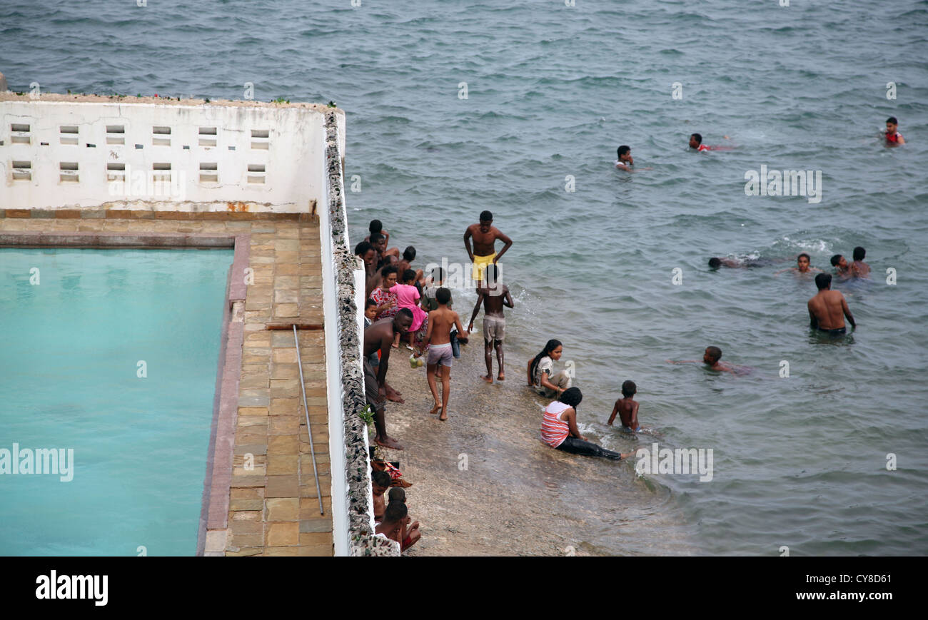 Gli abitanti del luogo nuotano nell'oceano accanto a una piscina vuota del Mombasa Club, la città vecchia, Mombasa, Kenya, Africa orientale. 8/2/2009. Fotografia: Stuart Boulton Foto Stock