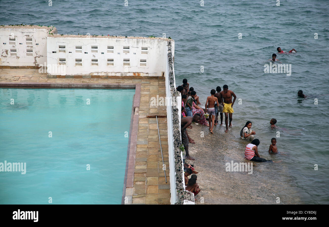 Gli abitanti del luogo nuotano nell'oceano accanto a una piscina vuota del Mombasa Club, la città vecchia, Mombasa, Kenya, Africa orientale. 8/2/2009. Fotografia: Stuart Boulton Foto Stock