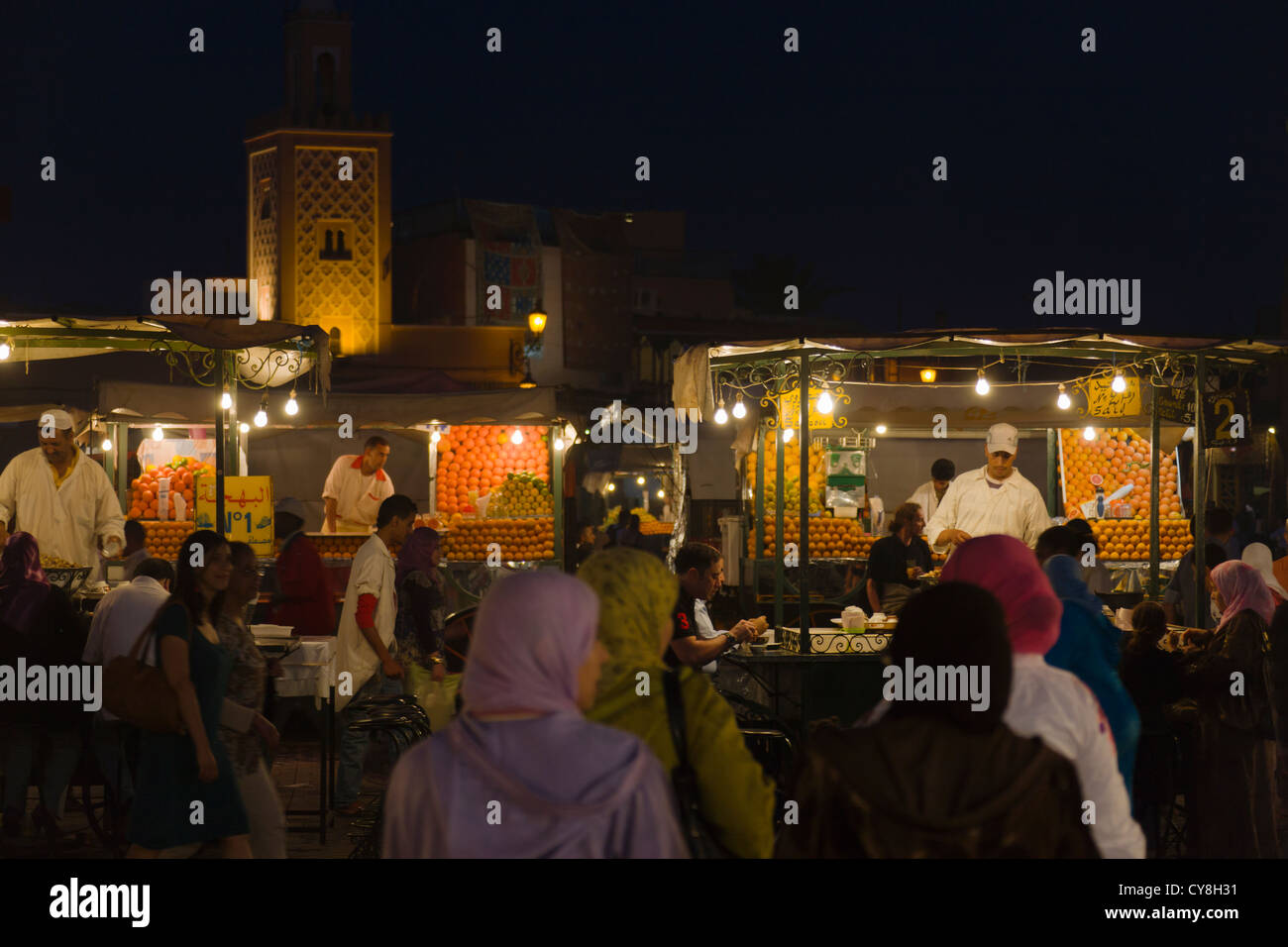 Vista notturna di mercato in piazza Jema al-Fna piazza dominata dalla Moschea di Koutoubia di Marrakech, Marocco Foto Stock