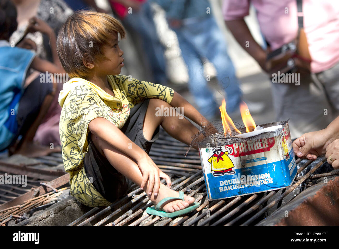 I bambini nel cimitero Calamba raccogliere più di sinistra dei pezzi di candele bruciato per raccogliere la cera che esse re-vendere a candela maker. Foto Stock