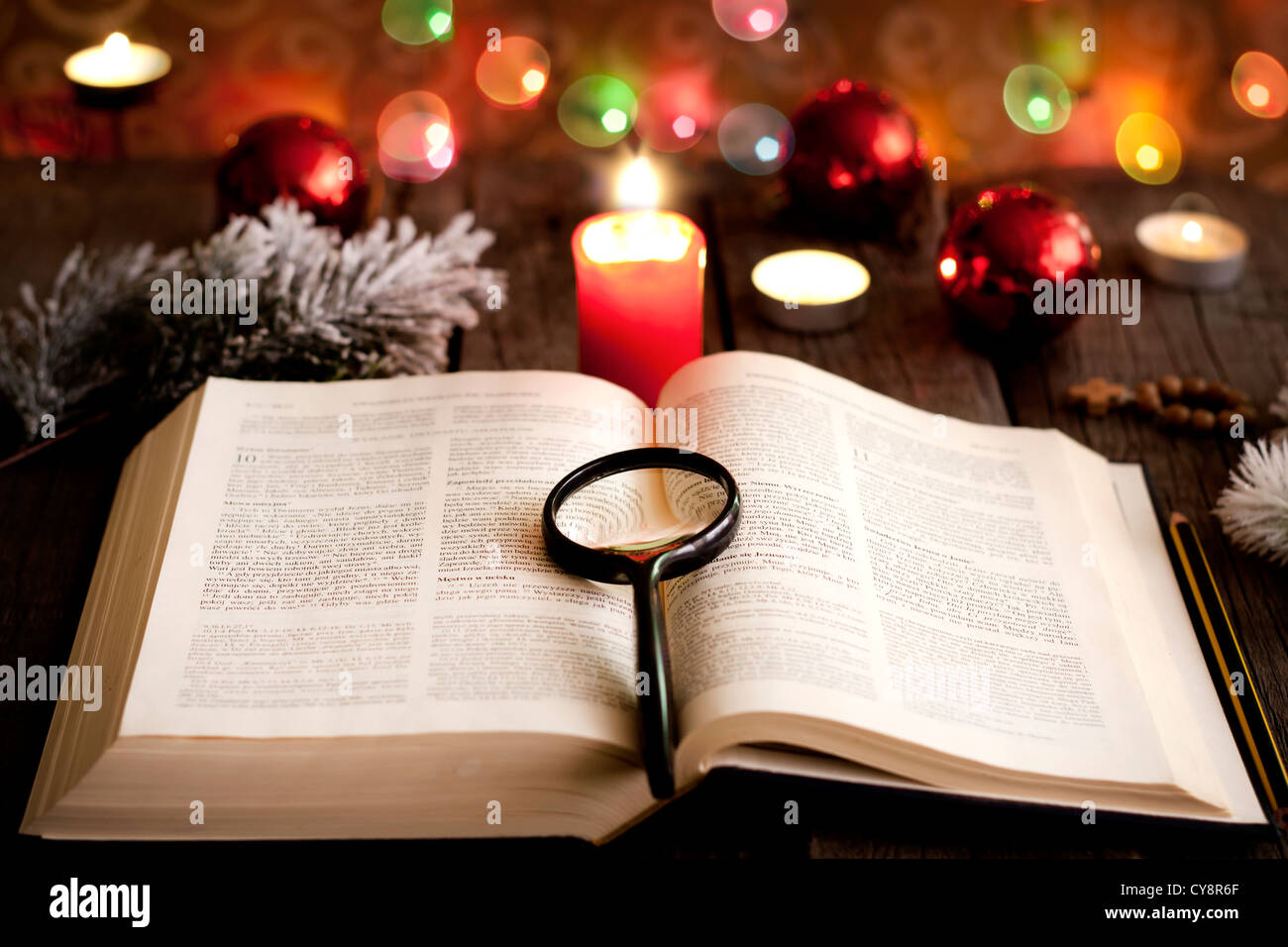 Il Natale e la bibbia con candele sfocata sfondo luminoso Foto Stock