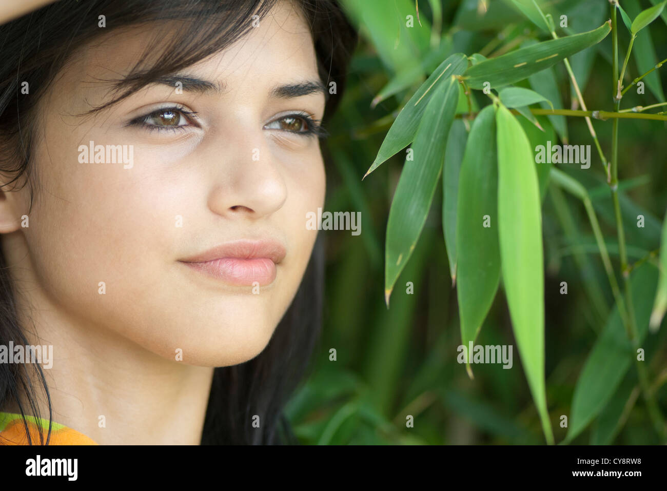 Giovane donna in foglie di bambù, ritratto Foto Stock