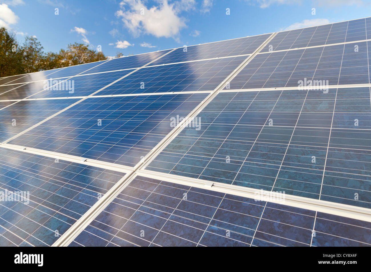 Solare fotovoltaico campo di pannelli per la produzione di energia da fonti rinnovabili con cielo blu e nuvole Foto Stock