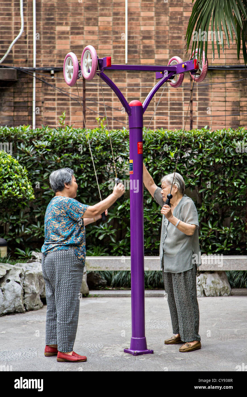 Anziani Le donne cinesi esercitano su di una macchina nella vecchia concessione francese di Shanghai in Cina Foto Stock