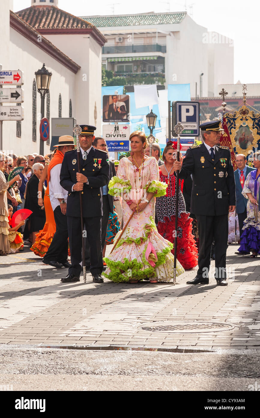Signora spagnola dignitario in abito spagnolo scortato da due alti poliziotti spagnoli. Processione religiosa. Fuengirola. Spagna. Foto Stock