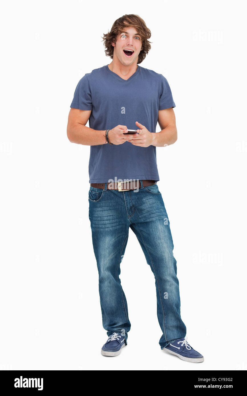 A bocca aperta studente in possesso di un telefono cellulare Foto Stock