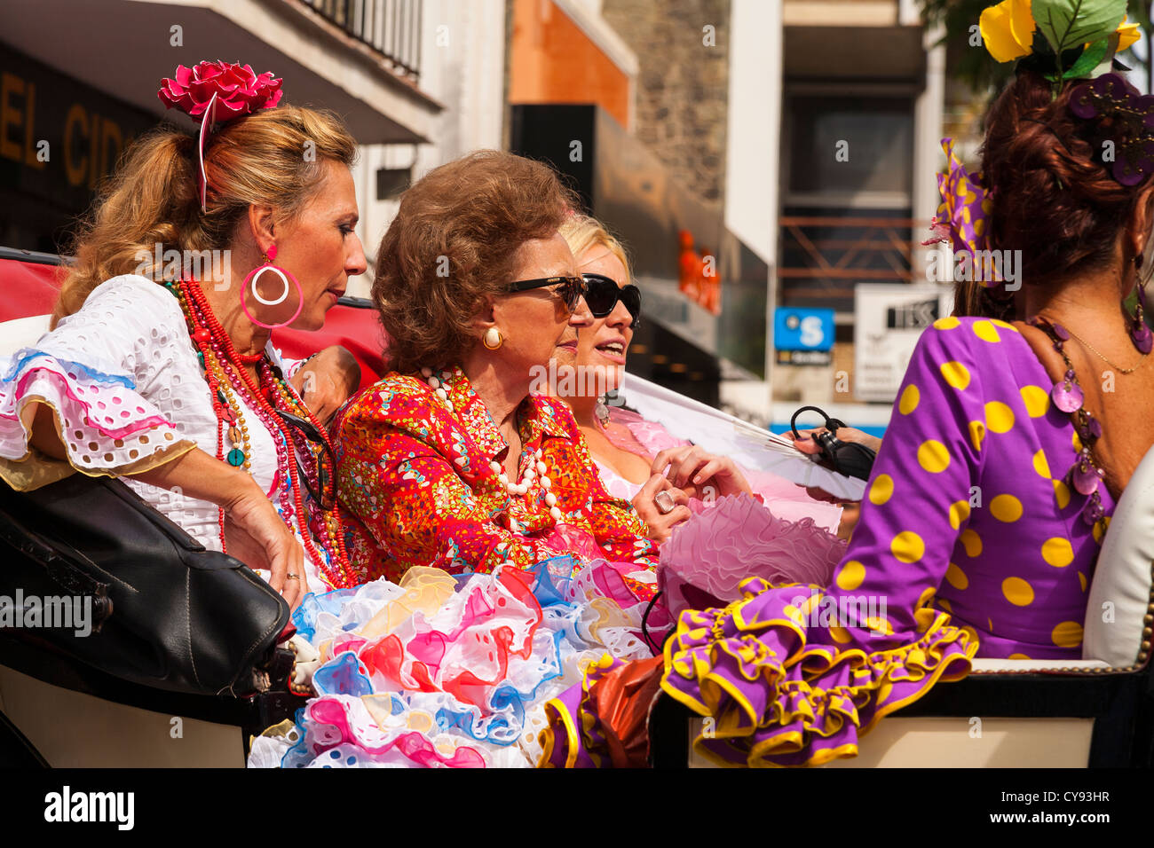 Signore spagnolo scorre in un carrello vestito in abito spagnolo. Processione religiosa. Fuengirola. Spagna. Foto Stock