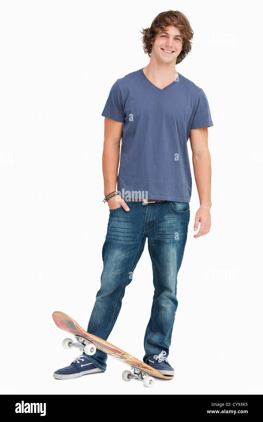Sorridente studente maschio con uno skateboard Foto Stock