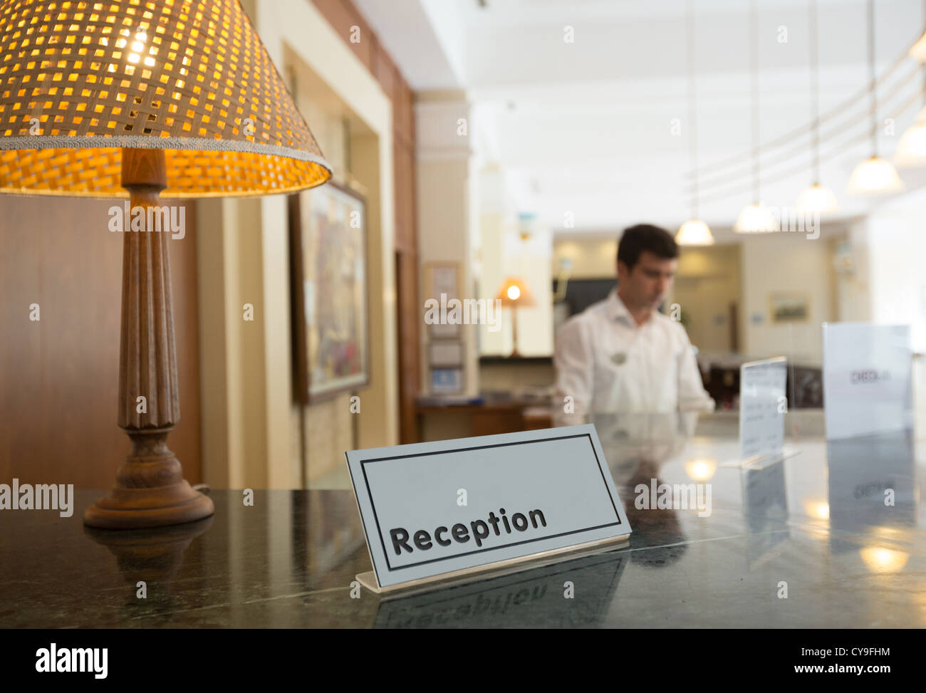 Hotel reception con una tabella e un addetto alla reception su uno sfondo Foto Stock