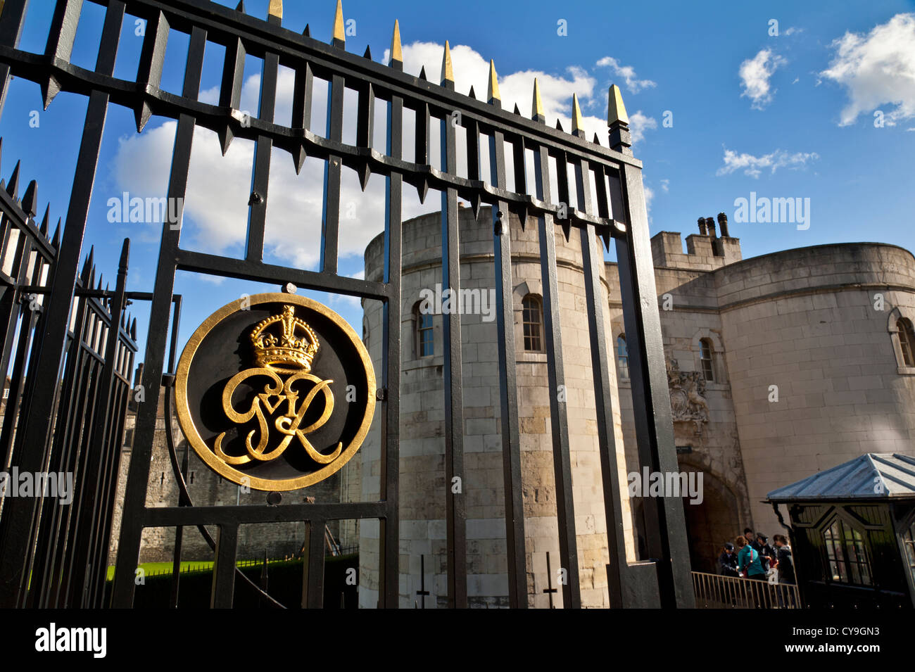 La Torre di Londra torre centrale ingresso con sicurezza turistica checkpoint e il sigillo reale del re George su cancelli in ferro Foto Stock