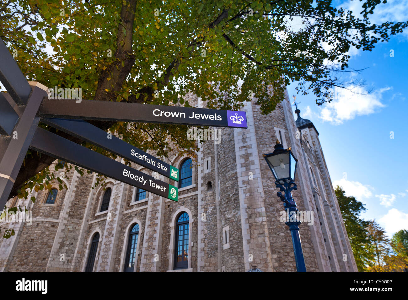 Crown Jewels, impalcatura, Bloody Tower, posto con cartello presso la Torre di Londra, che dirige i visitatori verso i punti di interesse edificio della Torre Bianca dietro Londra UK Foto Stock