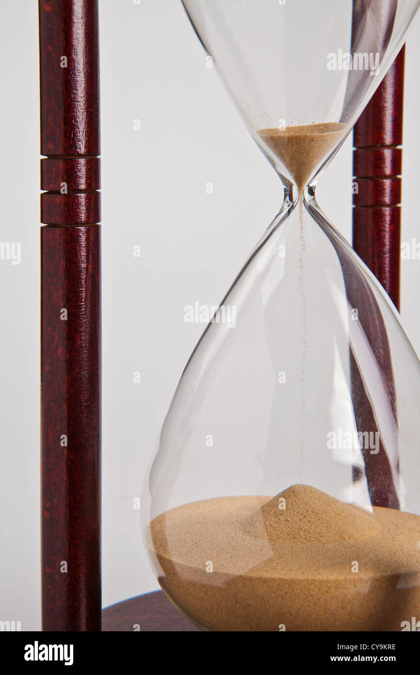 Sabbia orologio timer clessidra clessidra sabbia grani di clock in esecuzione fuori.. isolata contro uno sfondo bianco Foto Stock