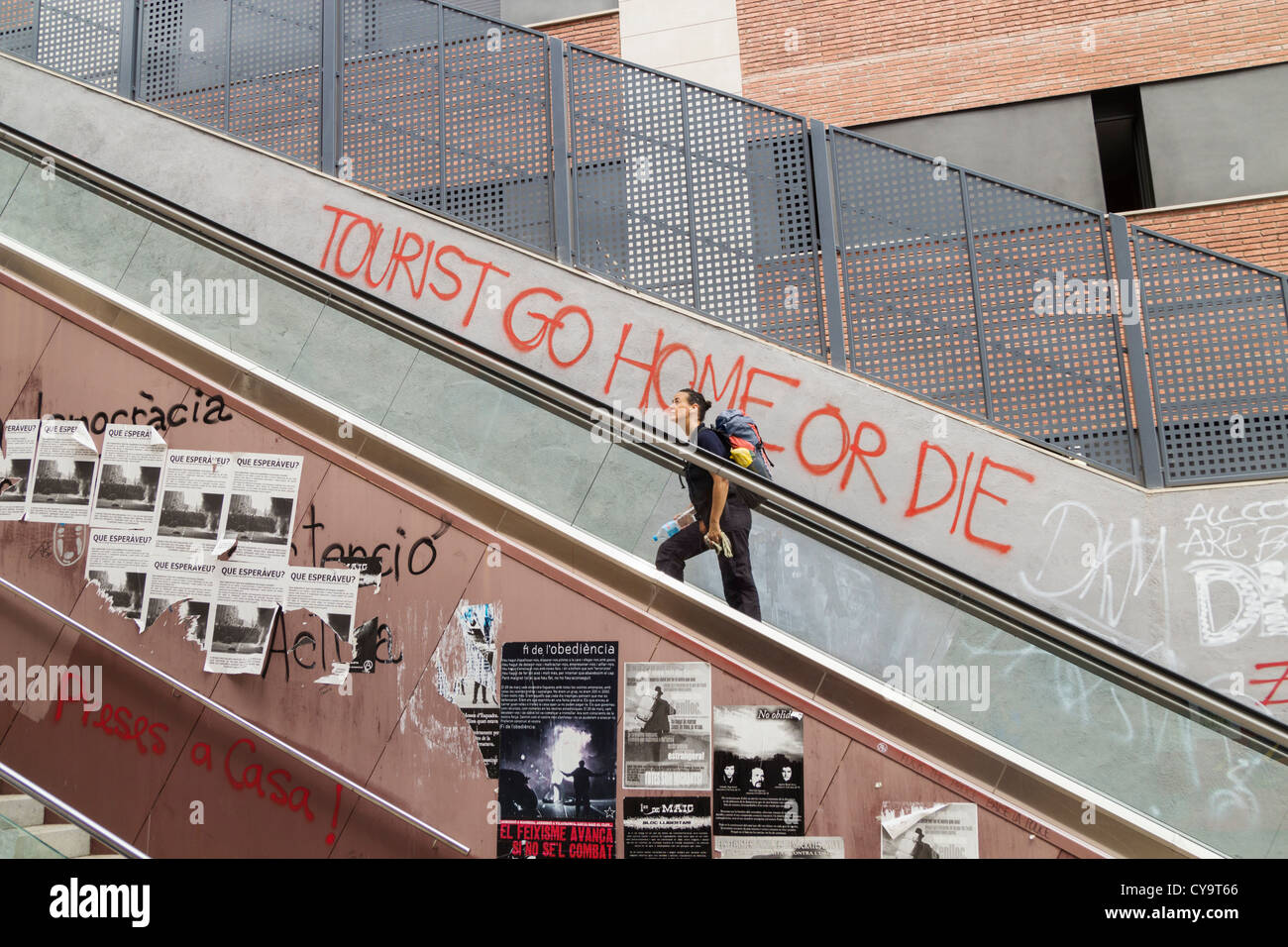 'Tourist go home or die' a muro vicino scala mobile a Barcellona, Spagna. Concetto di coronavirus... Foto Stock