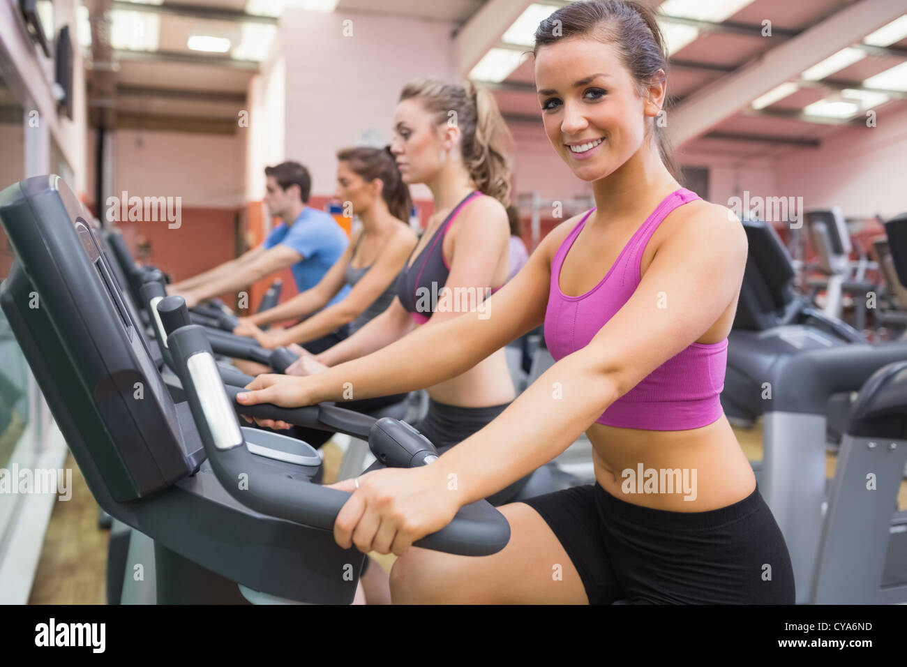 Donna sorridente sulla cyclette Foto Stock