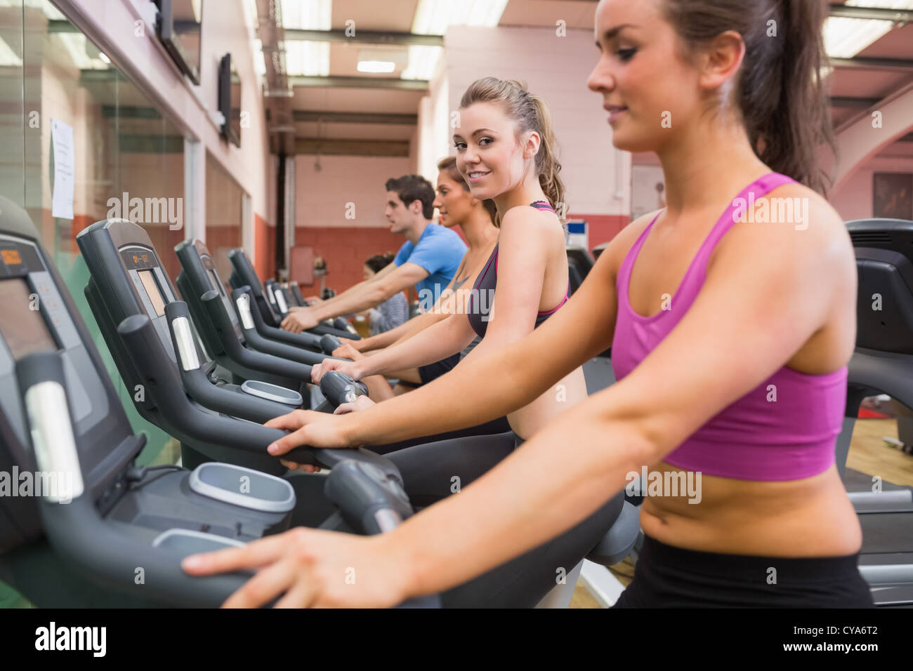Donna sorridente mentre sulla cyclette Foto Stock