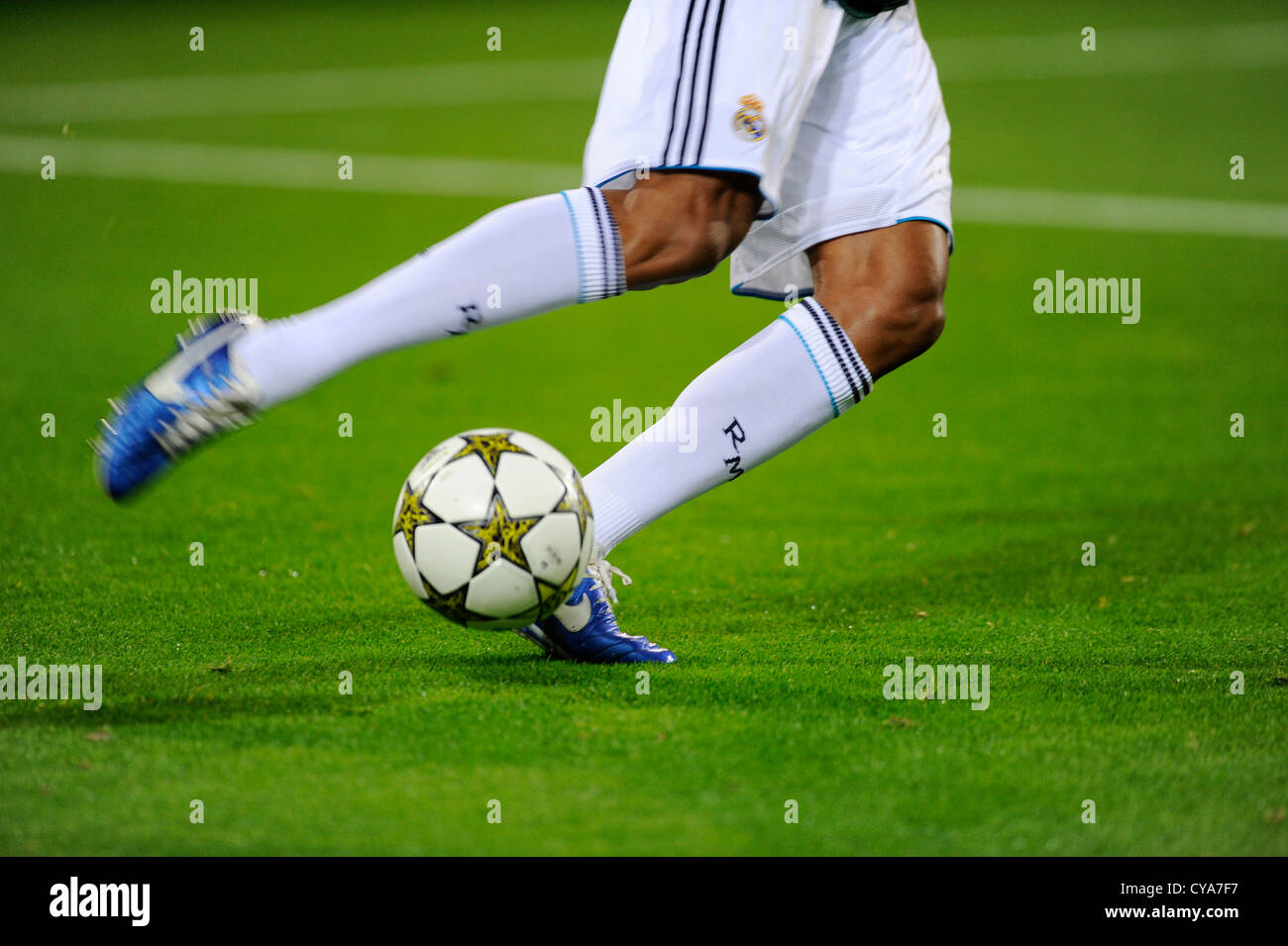 Le gambe di un Real Madrid Football giocatore gioca con la UEFA Champions League Ball Adidas finale 12 OMB del passo Foto Stock