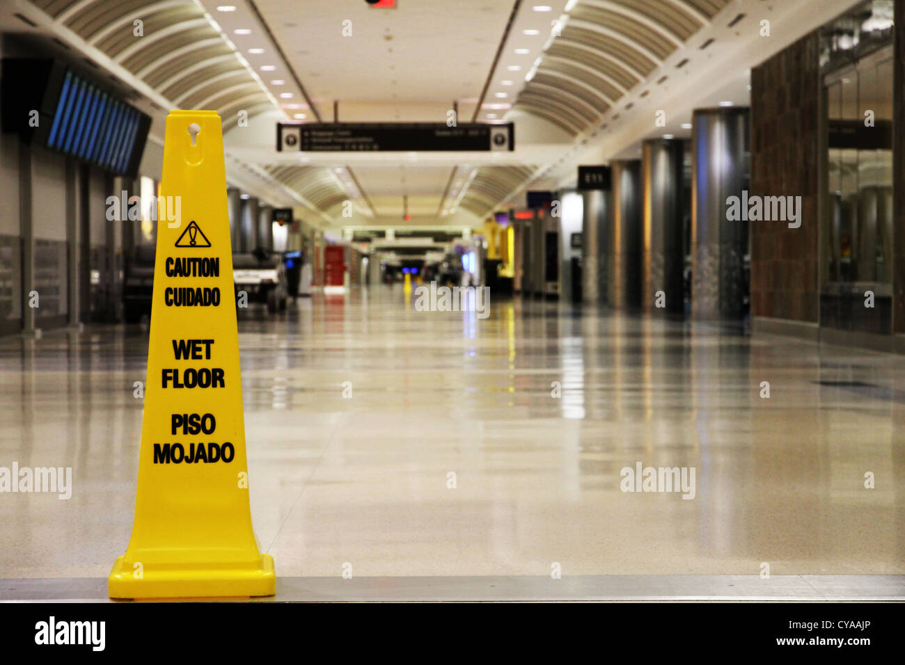 Un giallo "pavimento bagnato segno'' in un vuoto di airport terminal presso l'aeroporto di Atlanta, che è l'aeroporto più trafficato del mondo. Foto Stock