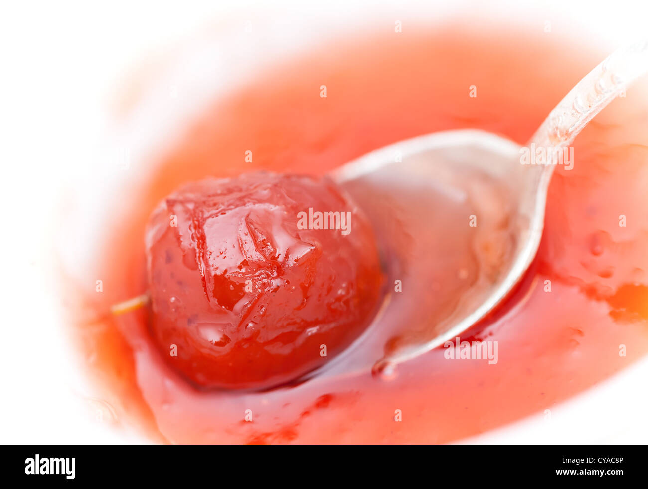 Piccolo cinese rosso Apple in una jam session con cucchiaio in metallo Foto Stock