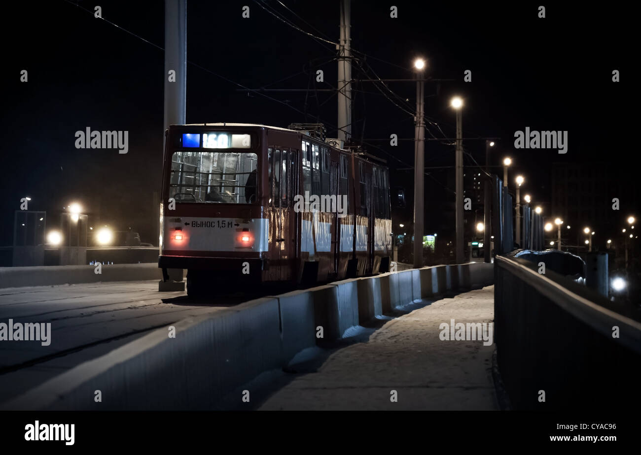 L'ultimo tram scorre su un ponte in una sera d'inverno Foto Stock