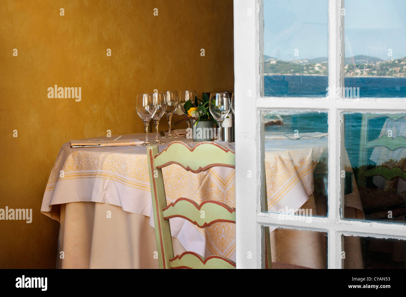 Tabella disposti in un ristorante e aprire la finestra. La riflessione del mare sulla finestra . Foto Stock